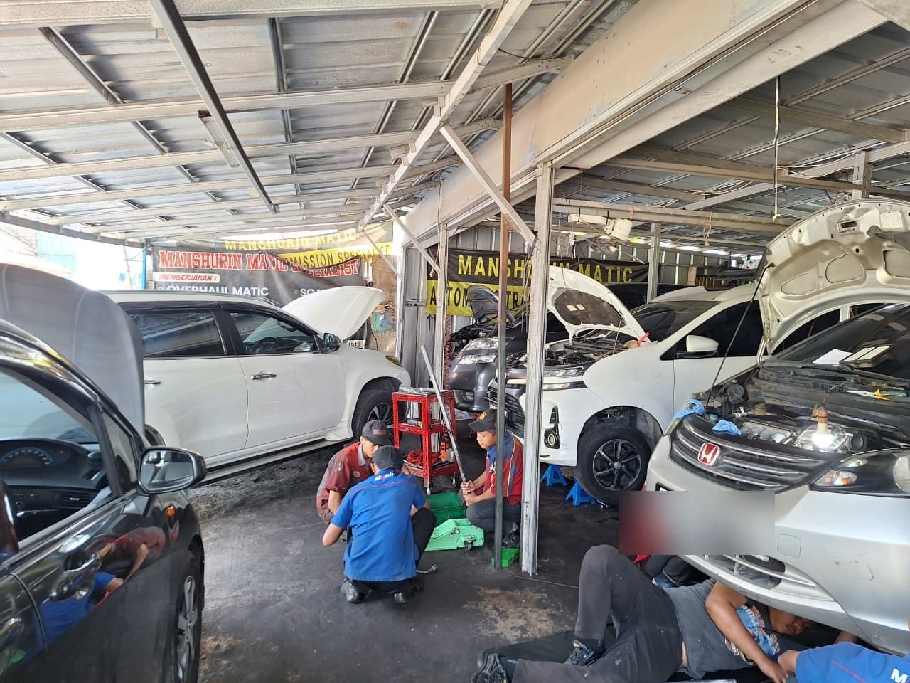 Tim mekanik menangani beberapa mobil sekaligus