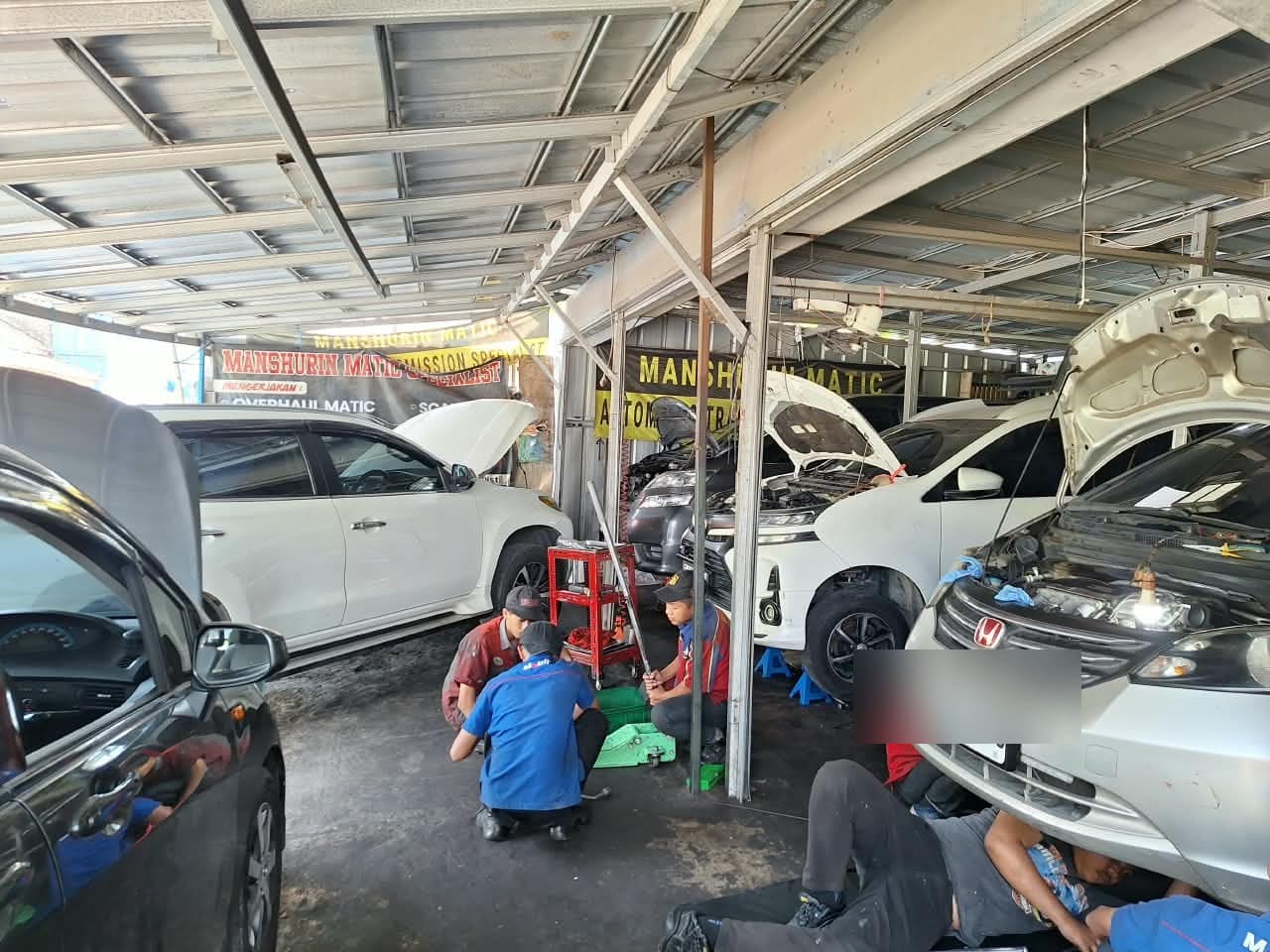 Mekanik Manshurin Matic sedang menangani transmisi mobil